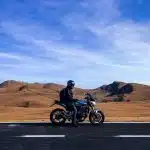 man riding motorcycle at vast land during daytime