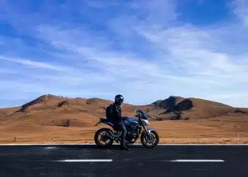 man riding motorcycle at vast land during daytime