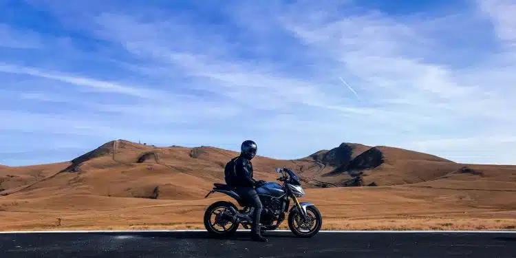 man riding motorcycle at vast land during daytime