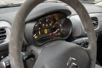 Voyants allumés sur le tableau de bord d'une Citroën C3 après une révision, vue depuis le siège conducteur