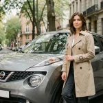 Femme debout à côté d'une Nissan Juke en ville, avis conductrice SUV au look sportif