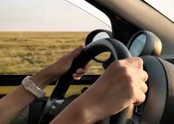 person with white watch driving car