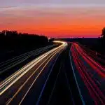 time-lapse photography of road under gray and orange sky