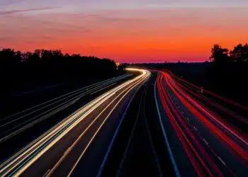time-lapse photography of road under gray and orange sky