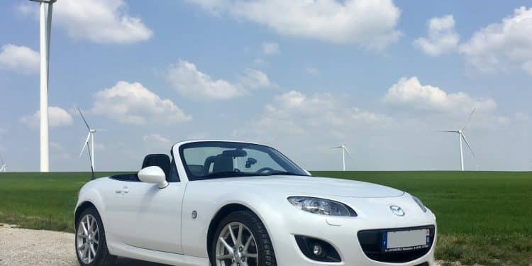 white porsche 911 on green grass field under blue sky during daytime