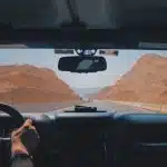person driving car on desert during daytime