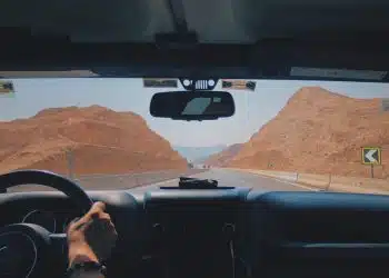 person driving car on desert during daytime
