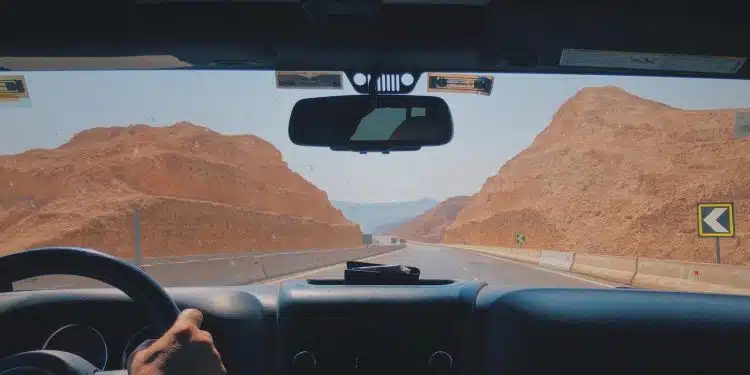 person driving car on desert during daytime